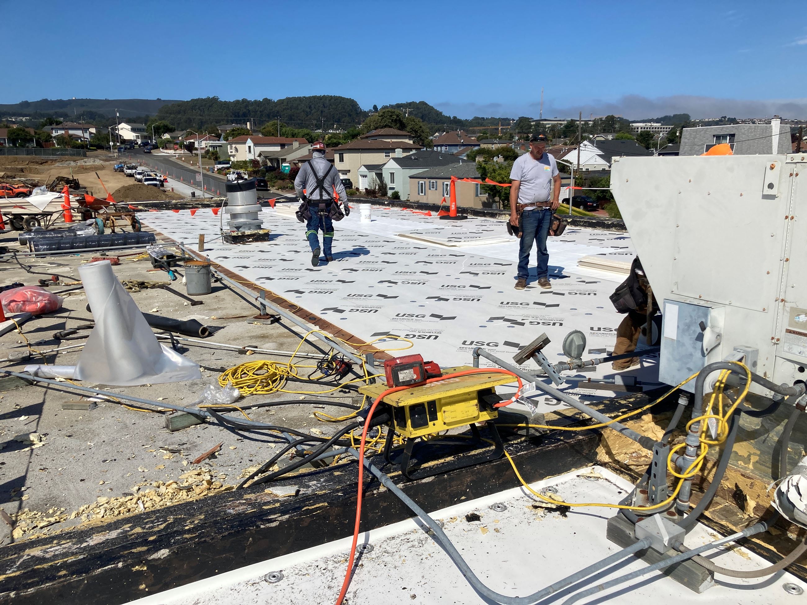 Image of workers on rooftop installing HVAC system